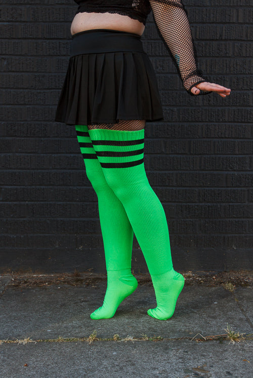A person wearing Electric Shock thigh highs in neon green with black stripes