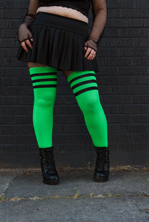 A person wearing Electric Shock thigh highs in neon green with black stripes