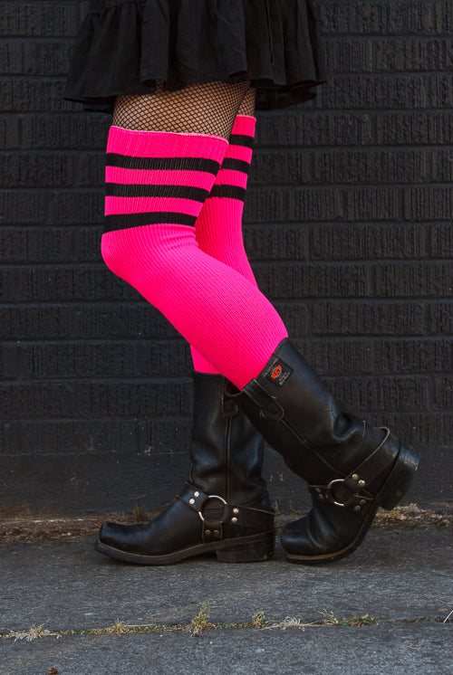 A person wearing Electric Shock thigh highs in neon pink with black stripes