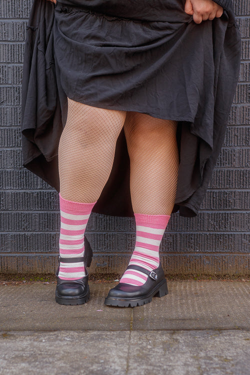 A person wearing simply striped tube socks in bubblegum and sweet cream