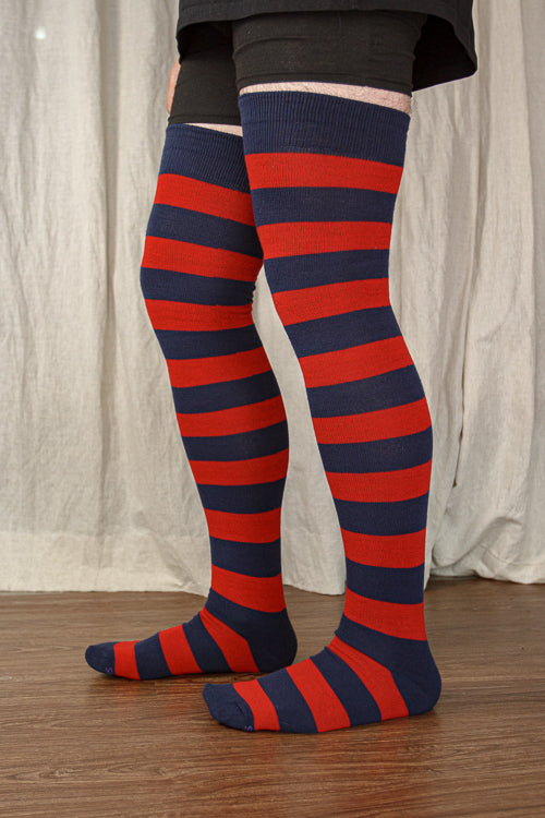A person wearing XL foot longer extraordinary programming socks in navy and red