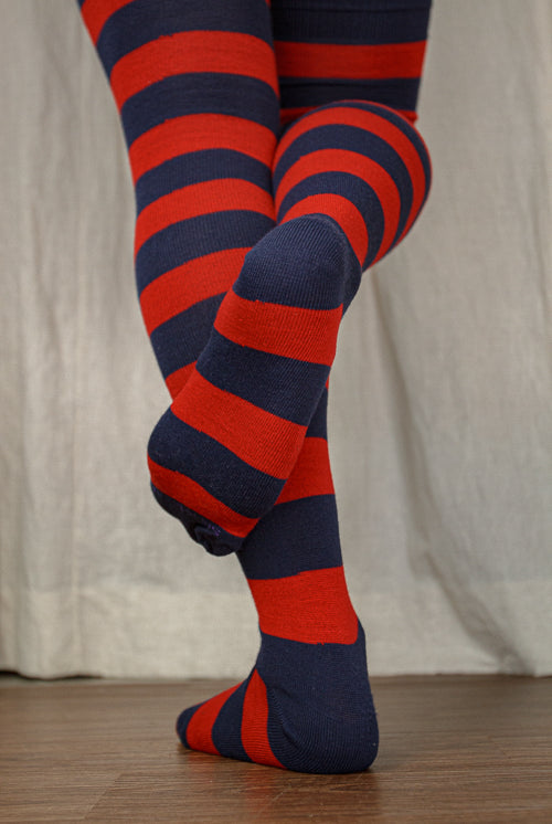 A person wearing XL foot longer extraordinary programming socks in navy and red