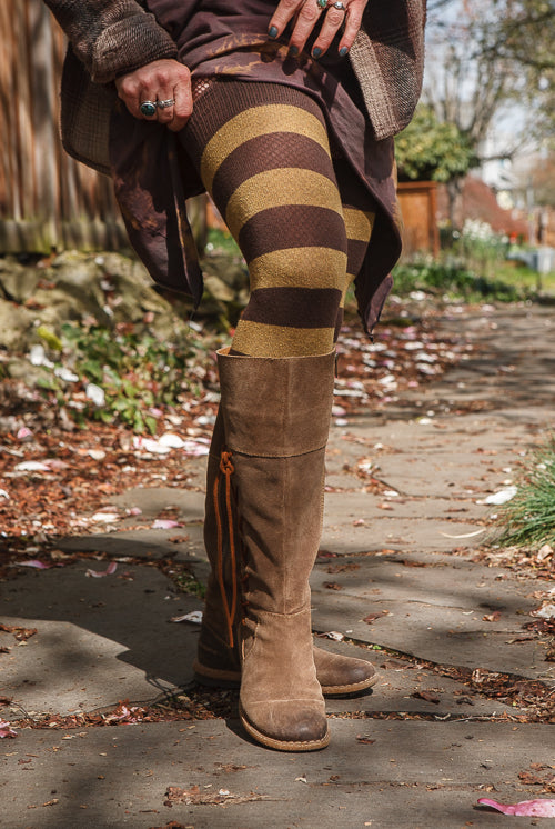 A person wearing longer striped extraordinary thigh highs in coffee and ochre