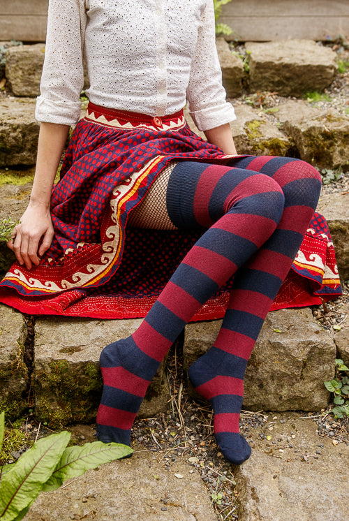 A person wearing striped extraordinary thigh highs in navy and burgundy