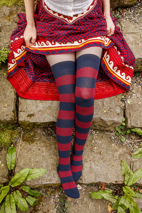 A person wearing striped extraordinary thigh highs in navy and burgundy