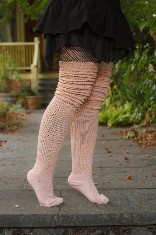 A person wearing long cuffable scrunchable socks in toe beans pink