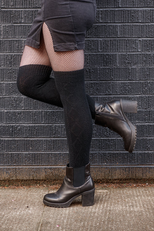 A person wearing longer diamond rib knee socks in black