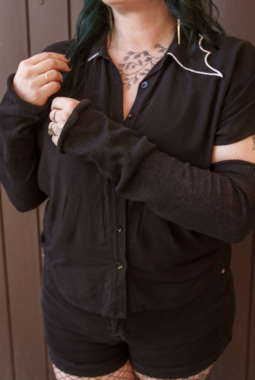 A person wearing longer M sleeves, in black