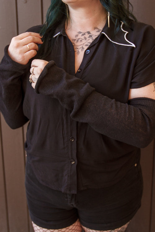 A person wearing longer M sleeves, in black