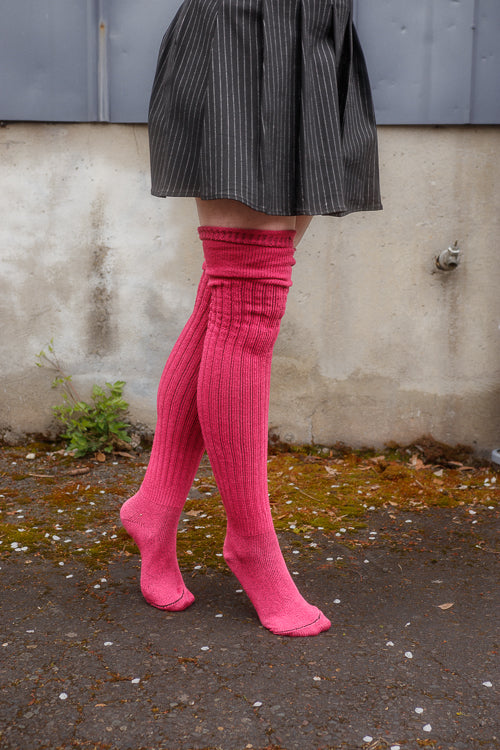 A person wearing M45 roll top thigh high socks in fuchsia