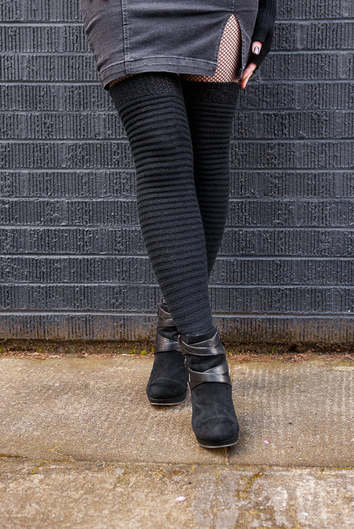 A person wearing Slinky thigh high socks in black.