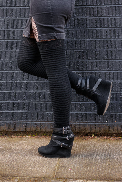A person wearing Slinky thigh high socks in black.