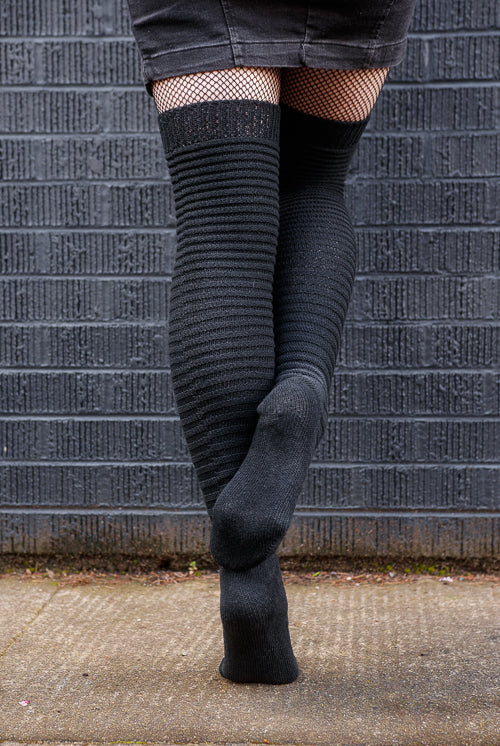 A person wearing Slinky thigh high socks in black.