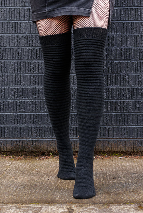 A person wearing Slinky thigh high socks in black.