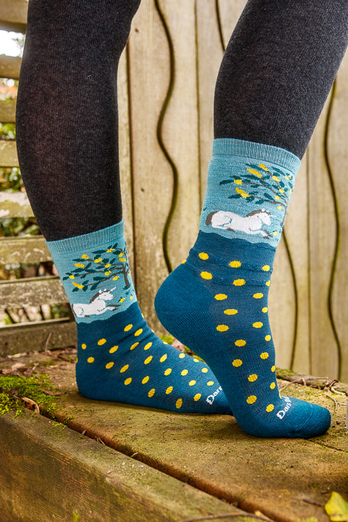 A person wearing unicorn wildlife crew socks in dark teal