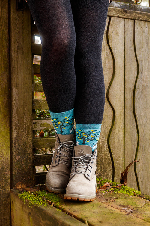A person wearing unicorn wildlife crew socks in dark teal