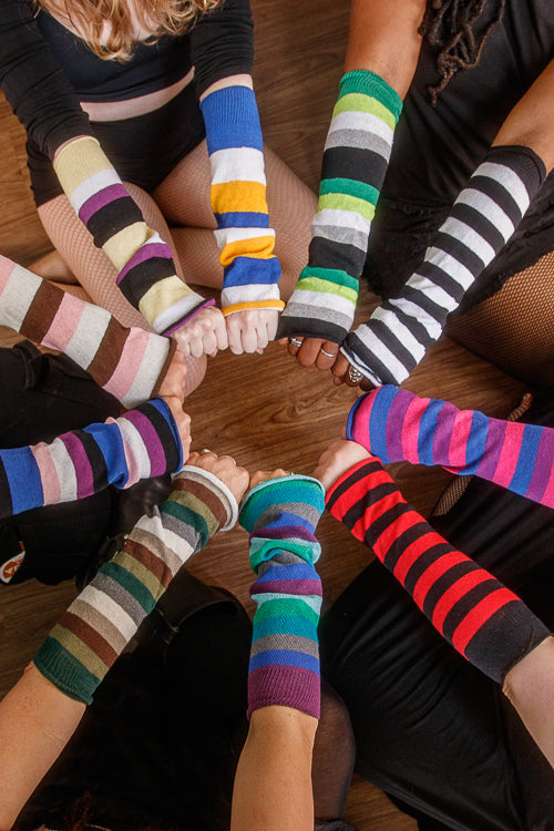 A circle of people wearing mismatched striped sleeves