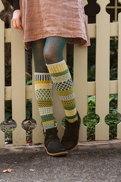 A person wearing fiddlehead knee high socks in various greens
