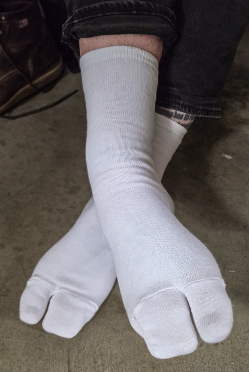 A person wearing white, large foot Tabi Socks