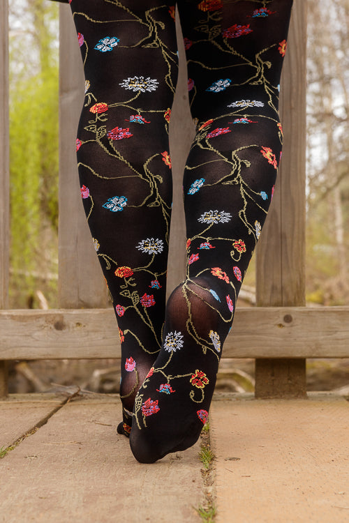 A person wearing Platino floral tights with colorful flowers