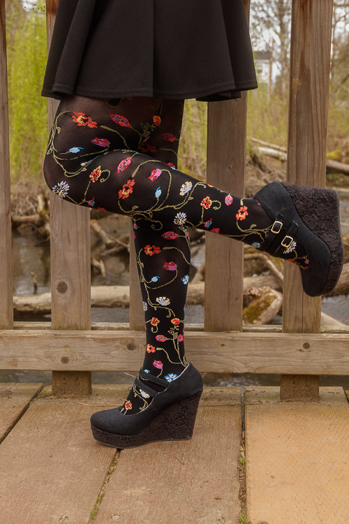 A person wearing Platino floral tights with colorful flowers