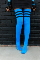 A person wearing Electric Shock thigh highs in neon blue with black stripes
