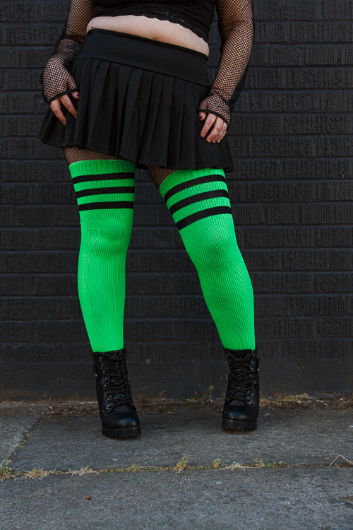 A person wearing Electric Shock thigh highs in neon green with black stripes