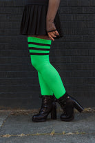 A person wearing Electric Shock thigh highs in neon green with black stripes