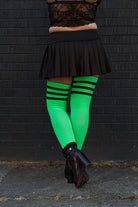 A person wearing Electric Shock thigh highs in neon green with black stripes