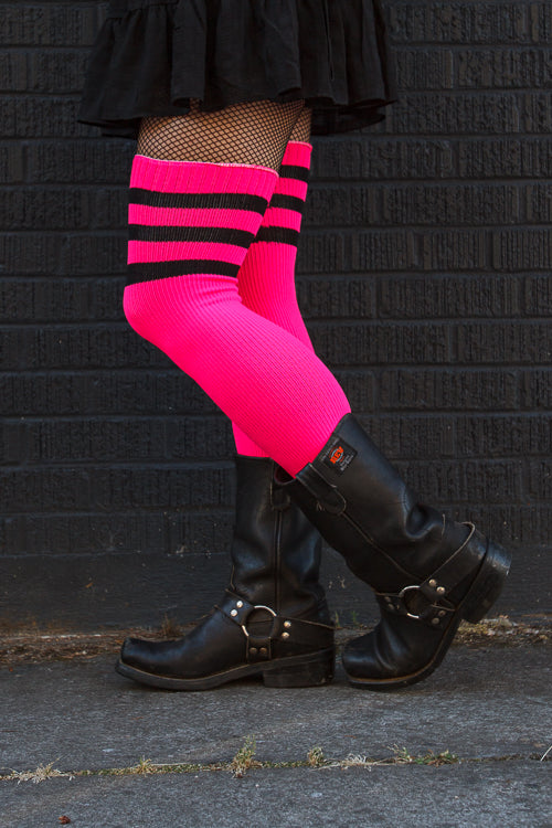 A person wearing Electric Shock thigh highs in neon pink with black stripes