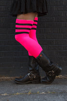 A person wearing Electric Shock thigh highs in neon pink with black stripes