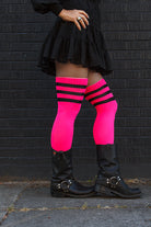 A person wearing Electric Shock thigh highs in neon pink with black stripes