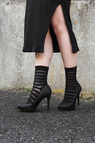 A person wearing Gossamer striped crew socks in black