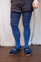 A person wearing xl foot longer gradient extraordinary thigh highs in navy and azule