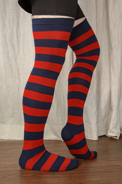A person wearing XL foot longer extraordinary programming socks in navy and red
