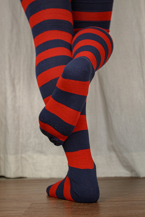 A person wearing XL foot longer extraordinary programming socks in navy and red