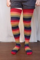 A person wearing XL foot longer harvest rainbow thigh highs in rainbow stripes