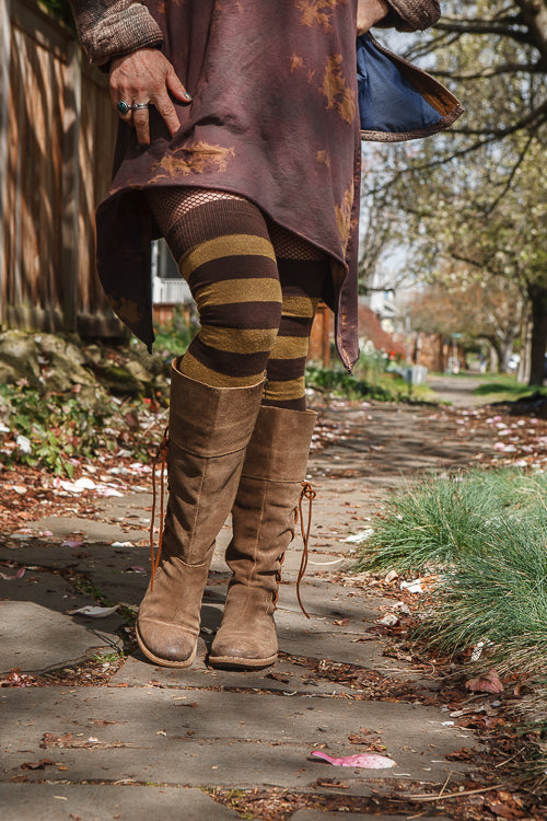 A person wearing longer striped extraordinary thigh highs in coffee and ochre