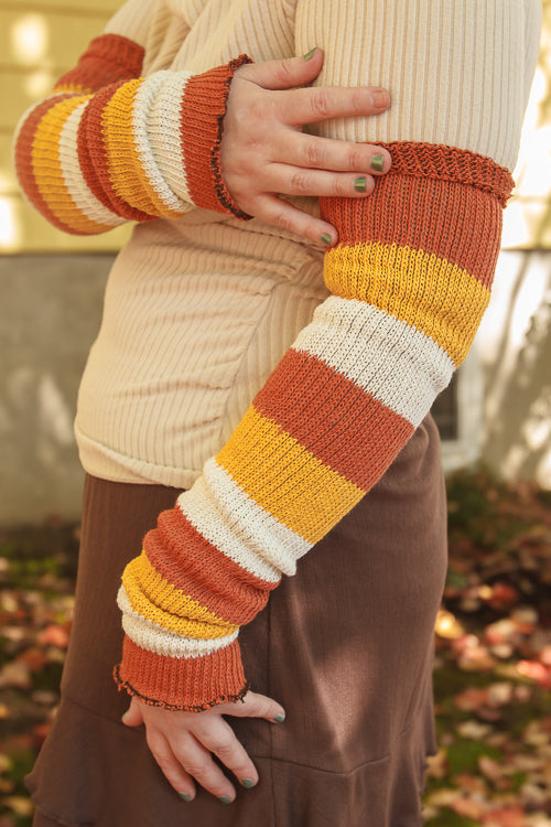 A person wearing Candy Corn striped warmers