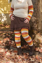 A person wearing Candy Corn striped warmers and matching thigh highs