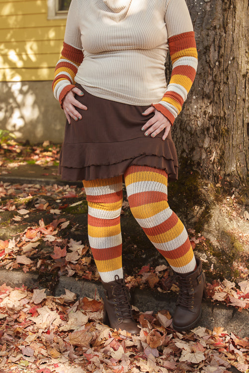 A person wearing Candy Corn striped warmers and matching thigh highs