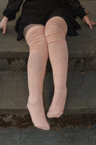 A person wearing long cuffable scrunchable socks in toe beans pink