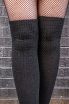A person wearing longer diamond rib knee socks in black