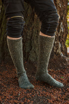 A person wearing OG Bootsocks in green