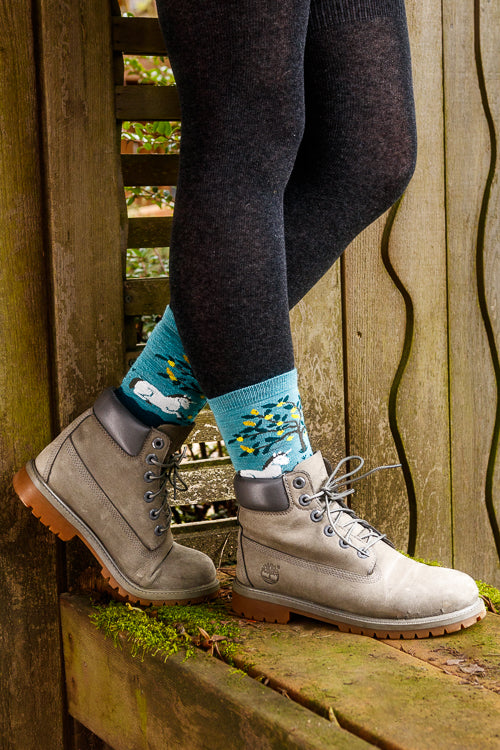 A person wearing unicorn wildlife crew socks in dark teal
