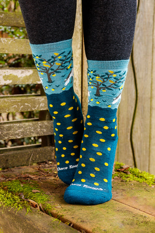 A person wearing unicorn wildlife crew socks in dark teal