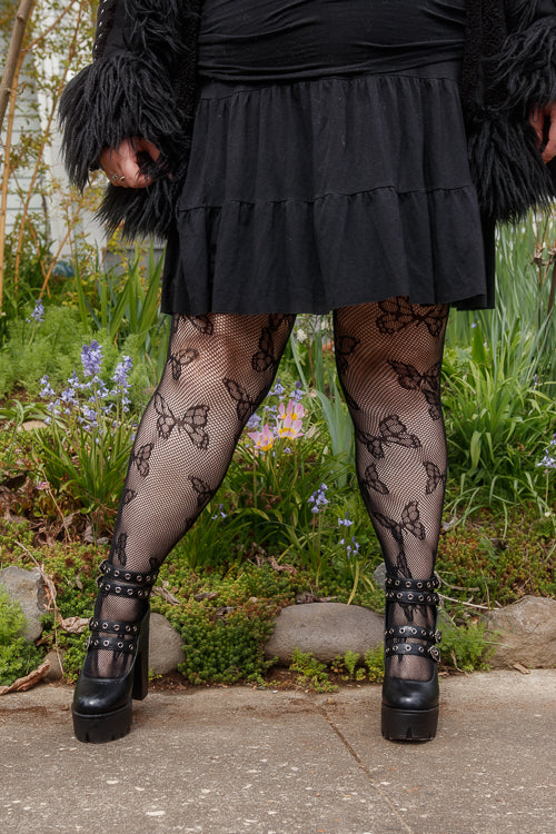 A person wearing Plus size butterfly net tights in black