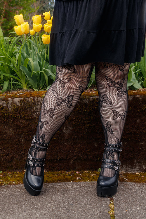 A person wearing Plus size butterfly net tights in black
