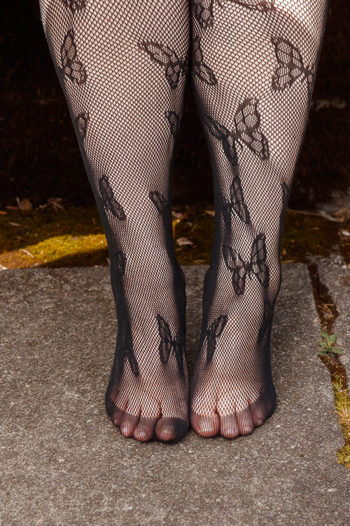 A person wearing Plus size butterfly net tights in black