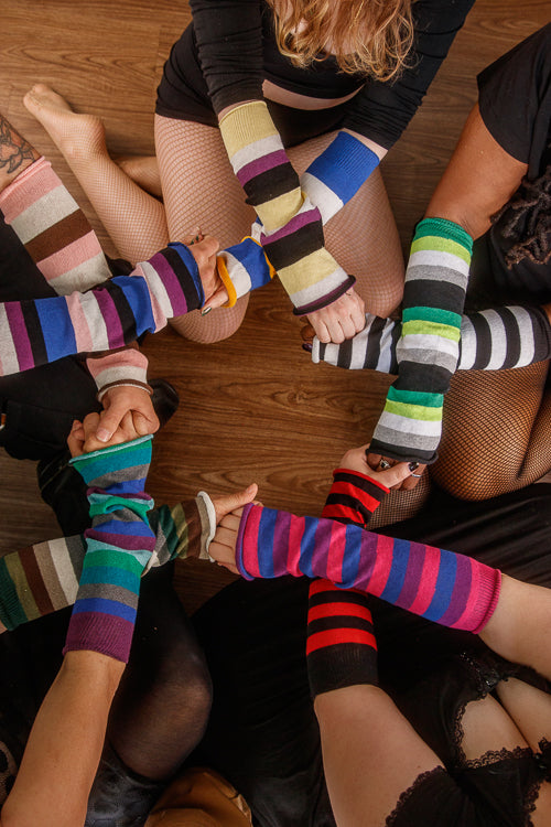 A circle of people wearing mismatched striped sleeves
